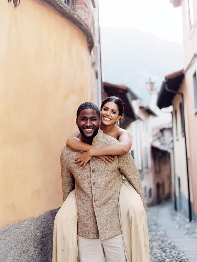 Groom lifting bride on a sunlit cobblestone street, editorial wedding portrait by Michigan Luxury Weddings
