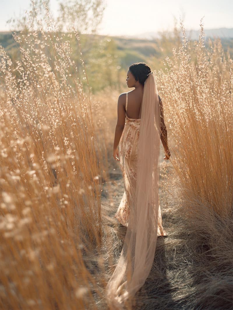 Bride walking through golden tall grass at sunset, fine-art Michigan wedding portrait
